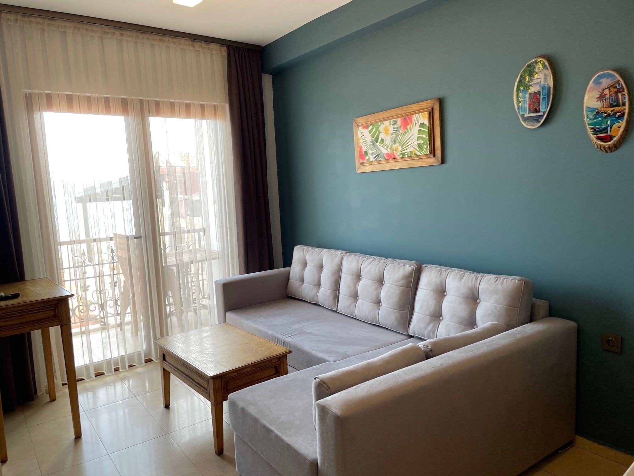 A living room with a sofa, a small table, and a painting on the wall.