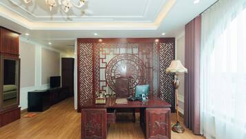 A room with a wooden desk, a computer, a lamp, and a decorative wall panel.