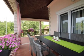 Enjoy a romantic dinner for two in this serene outdoor dining area, complete with a table, wicker chairs, and a beautiful potted plant.