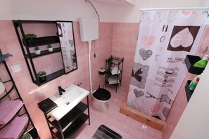 Bathroom features a sink, toilet, and shower with a heart-themed curtain.