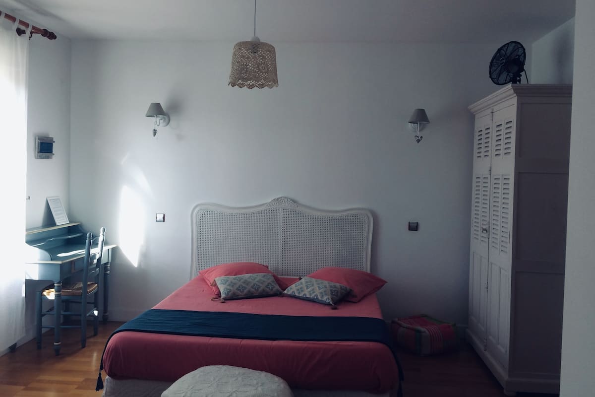 Une chambre à coucher avec un lit, un bureau et une armoire.