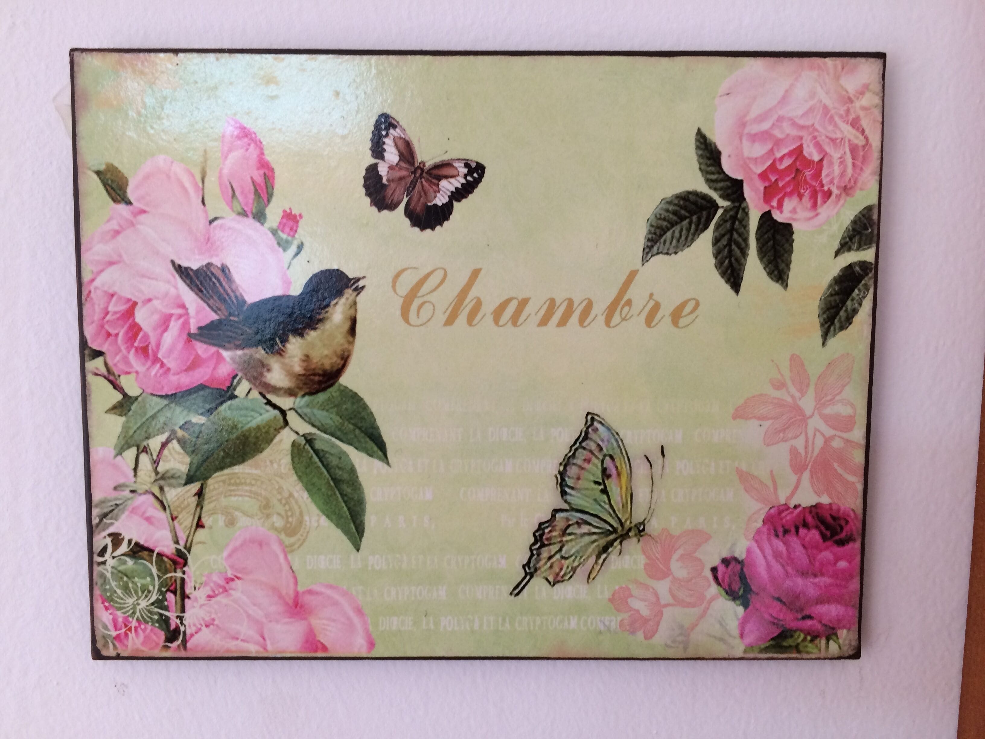 Un panel decorativo con diseños florales y de mariposas, que presenta la palabra 