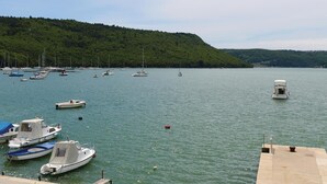 A marina with various boats docked, a small boat in the foreground, and a forested hill in the background. - 2 bedroom cozy home in Trget (Trget)