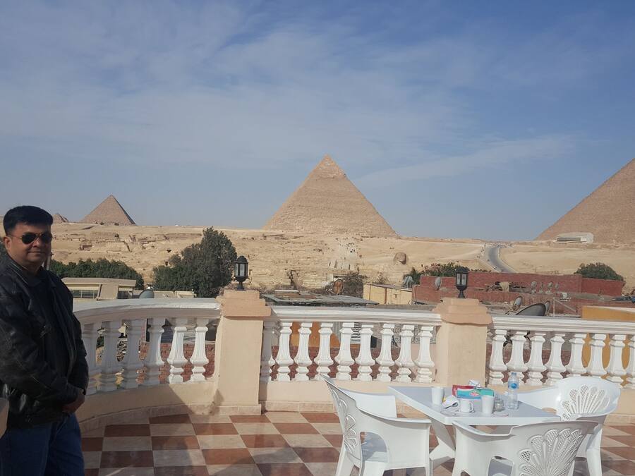 Un home al balcó amb vista a les piràmides.