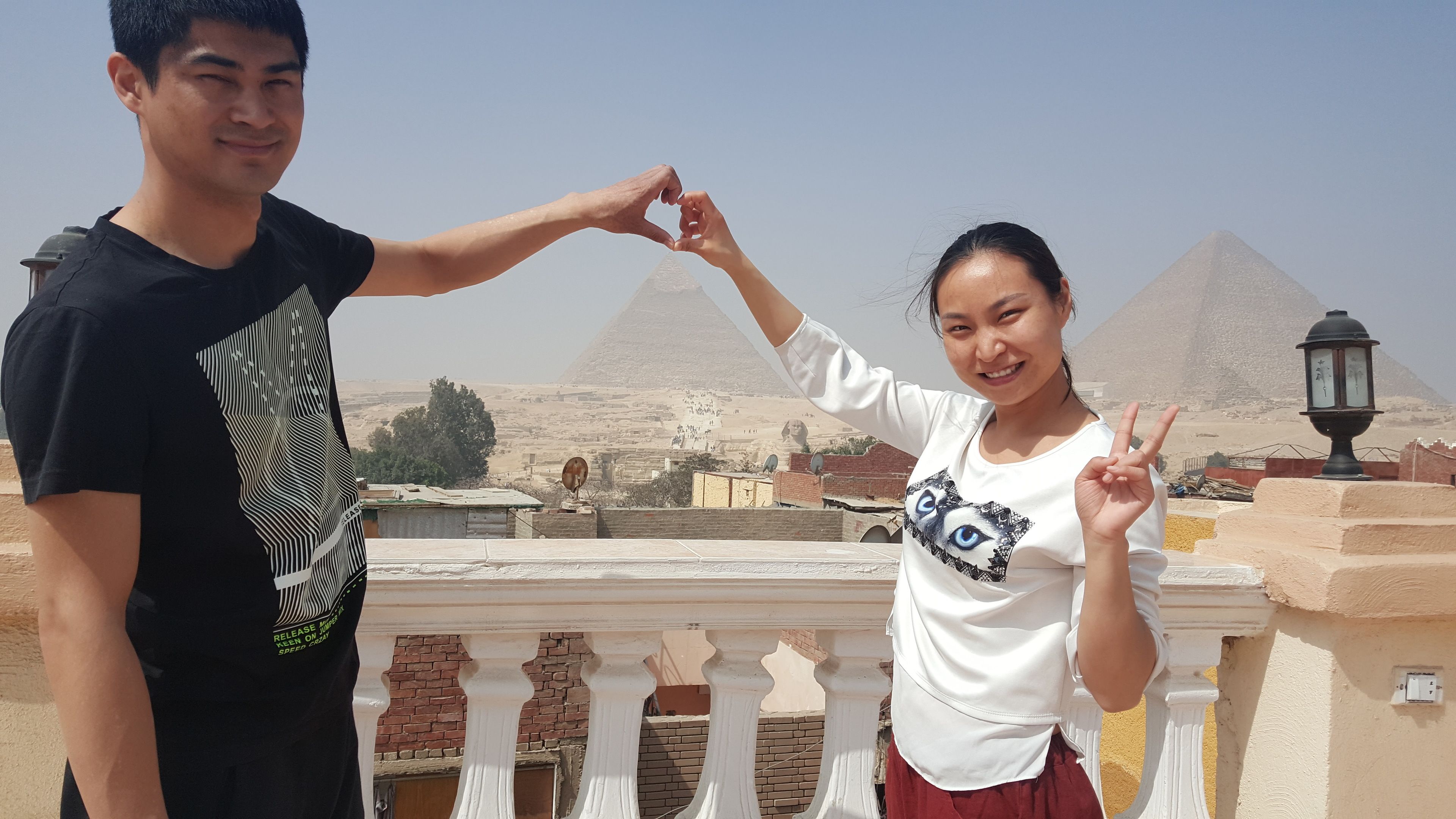 En balkon med udsigt til pyramider og en lygtepæl.