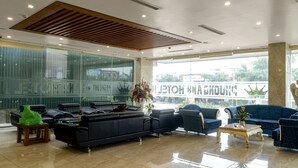 A modern lobby with leather sofas, a coffee table, and a large window with a view of the outside.