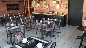 A restaurant with brick walls, wooden shelves, and tables set for dining. - Hôtel Le Dauphin (Saint-Denis-de-l'Hôtel)