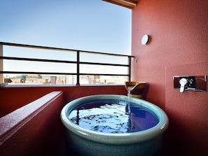 A bathroom with a large bathtub, a window with a view of the city, and a faucet. - Hotel WBF Grande Hakata (Fukuoka)