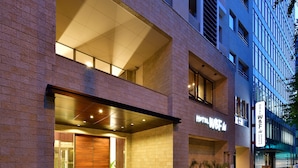 A hotel with a modern facade, large glass windows, and a prominent sign. - Hotel WBF Grande Hakata (Fukuoka)