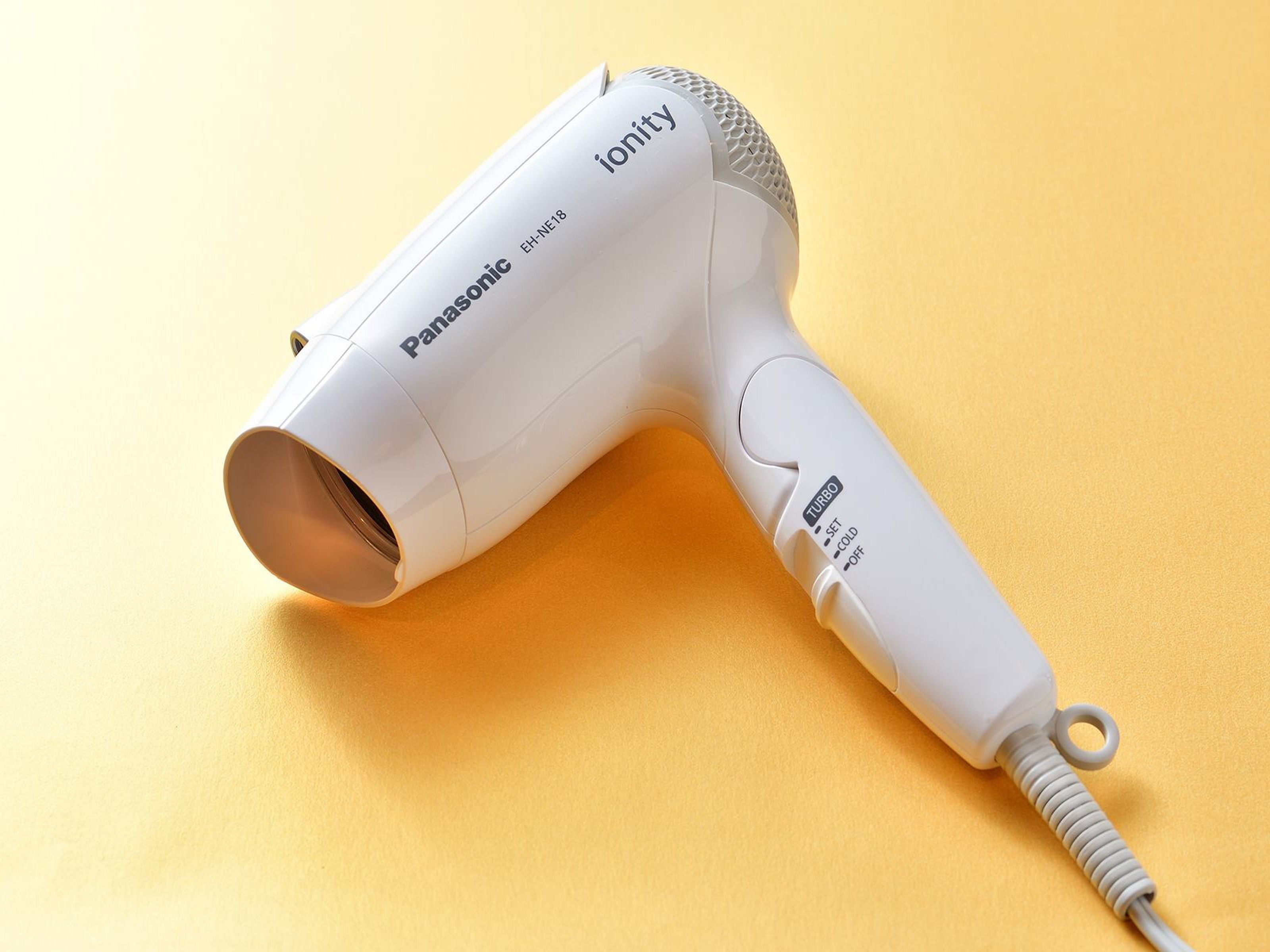 A Panasonic ionity hair dryer on a yellow surface.