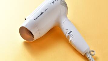 A Panasonic ionity hair dryer on a yellow surface.