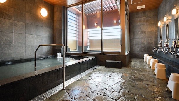 A modern bathroom with a stone floor, a large window, and a row of sinks with mirrors. - Hotel WBF Grande Hakata (Fukuoka)