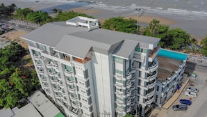 A high-rise hotel with multiple balconies, a swimming pool, and a beach view. - Jomtien Hisotel (Pattaya)