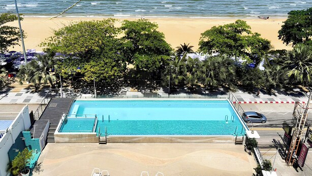A swimming pool with a view of the beach and ocean. - Jomtien Hisotel (Pattaya)