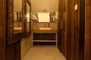 A narrow hallway with wooden walls and a sink with a mirror above it. - M Boutique Hostel Legian (Kuta)