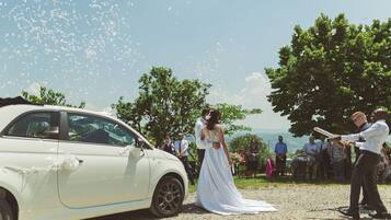 Una ceremonia de boda con un coche blanco e invitados.
