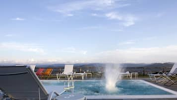 Una piscina al aire libre de temporada, sombrillas