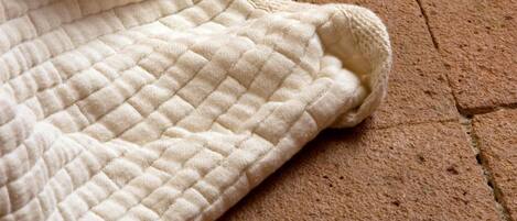 A quilted blanket on a brick floor.