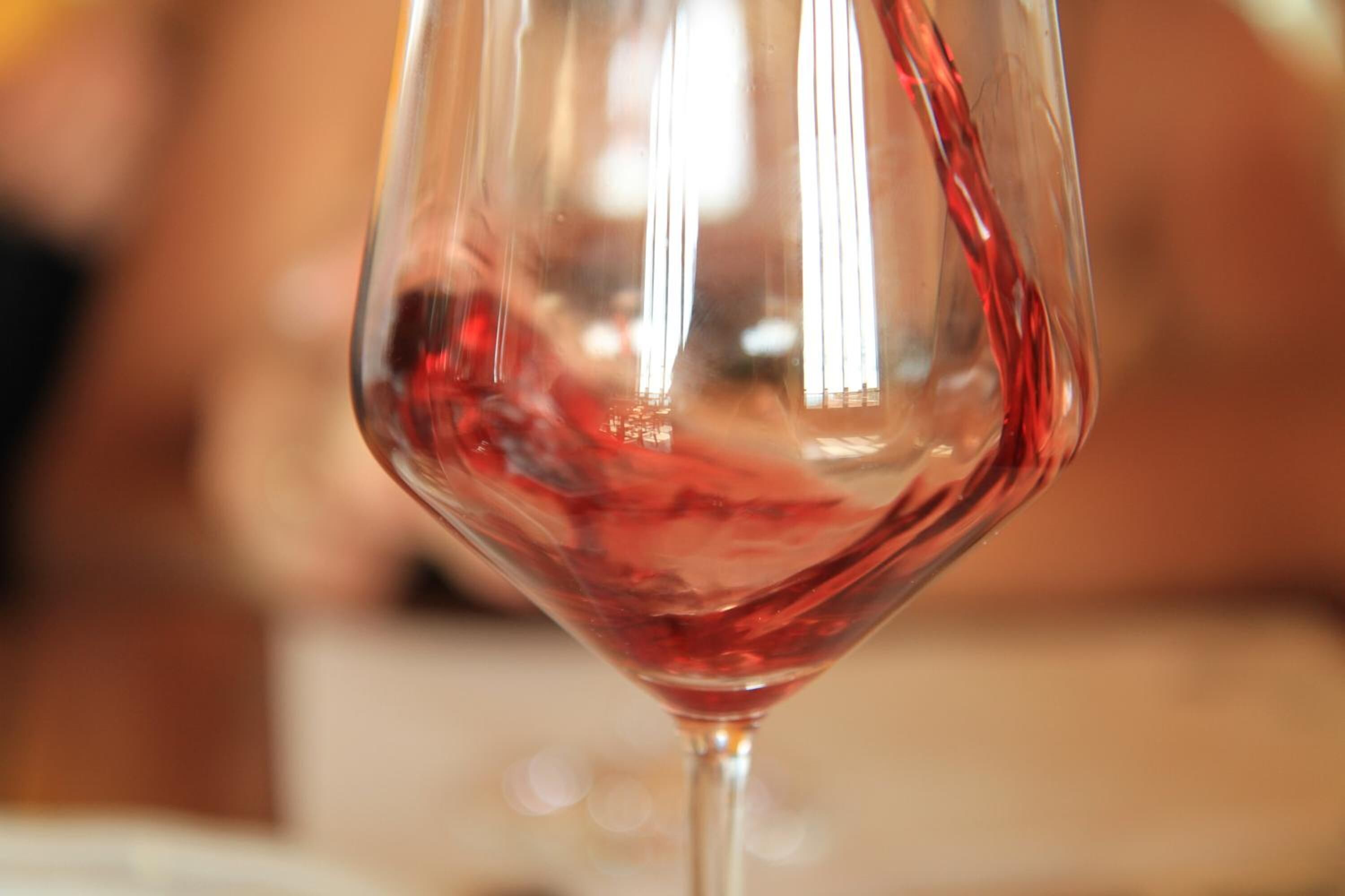 A close-up of a wine glass with red liquid.