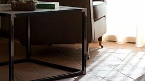 Una habitación moderna con un sofá, una mesita de centro y un florero con flores.