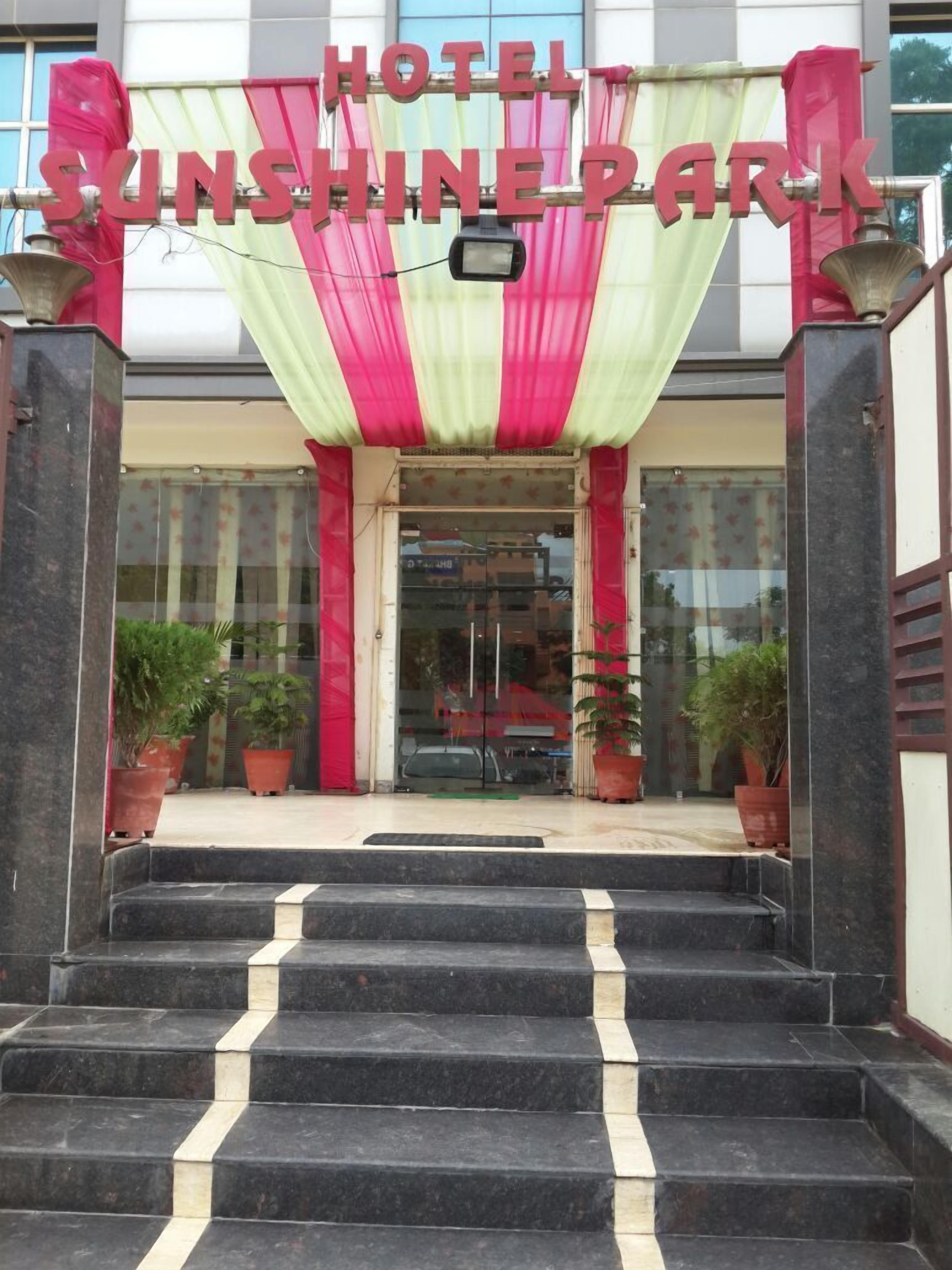 A hotel entrance with a sign reading "HOTEL SUNSHINE PARK".