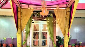 L’entrée d’un hôtel, dotée d’un espace d’entrée abrité, d’un escalier menant à l’intérieur et de plantes en pot disposées tout autour.