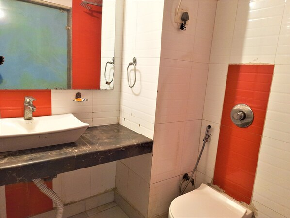 A bathroom with a sink, mirror, and shower.