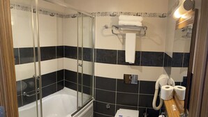 Un baño con ducha de vidrio, bañera, inodoro y lavamanos.