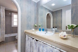 Een bad/douchecombinatie, een haardroger, een bidet, handdoeken