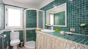 Een bad/douchecombinatie, een haardroger, een bidet, handdoeken