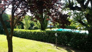 A well-maintained garden with a swimming pool, neatly trimmed hedges, and a lamp post. - Agriturismo Il Borghetto (Todi)