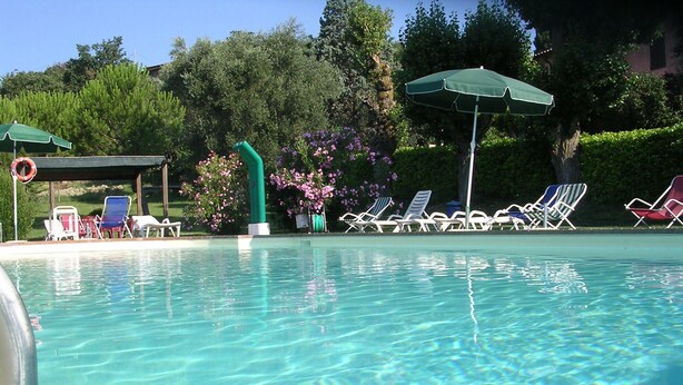 A clear swimming pool with lounge chairs and umbrellas. - Agriturismo Il Borghetto (Todi)