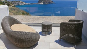 A balcony with wicker furniture, a clear view of the sea, and a small island in the distance. - Torre Sant'Angelo (Forio)