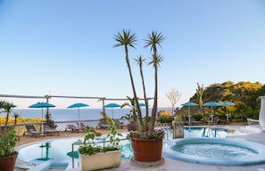 Piscine couverte, piscine extérieure, parasols de plage, chaises longues