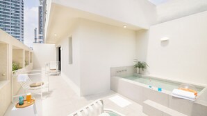 A modern bathroom with a bathtub, a small seating area with chairs, and a glass-enclosed shower. - H-AVENUE Hotel Seomyeon Station (Busan)