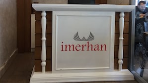 A reception desk with a sign reading "IMERHAN" and a framed certificate on the wall. - Imerhan Otel (Kusadasi)