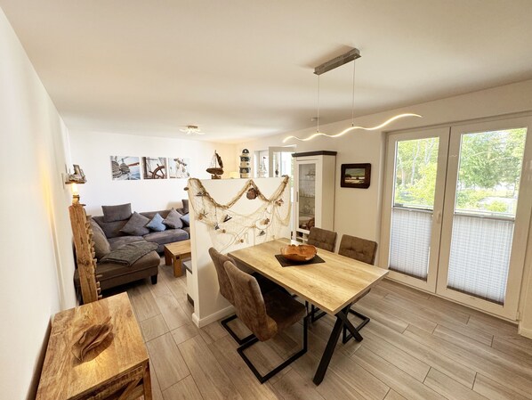 Un coin repas avec une table et des chaises en bois, un canapé et une décoration murale.