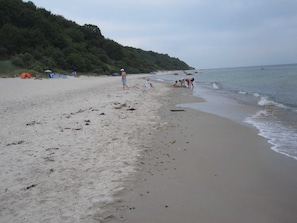 A beach with a sandy shore, a few tents, and people near the water. - Vacation apartment Elster (OG) - Windland Ranch - Riding stables with vacation apartments (House (Altenkirchen)