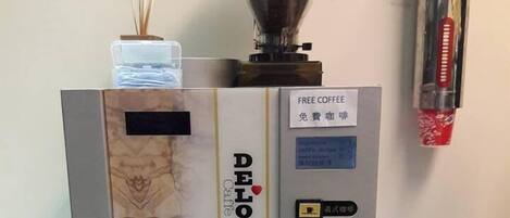Una máquina de café con pantalla digital, un molinillo de café y un dispensador de agua.