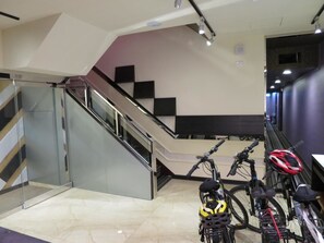 A modern indoor space with a staircase, glass railings, and bicycles. - Yung Feng Hotel (Keelung)