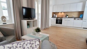 Ein modernes Wohnzimmer mit einer Couch, einem Couchtisch und einem Fernseher.