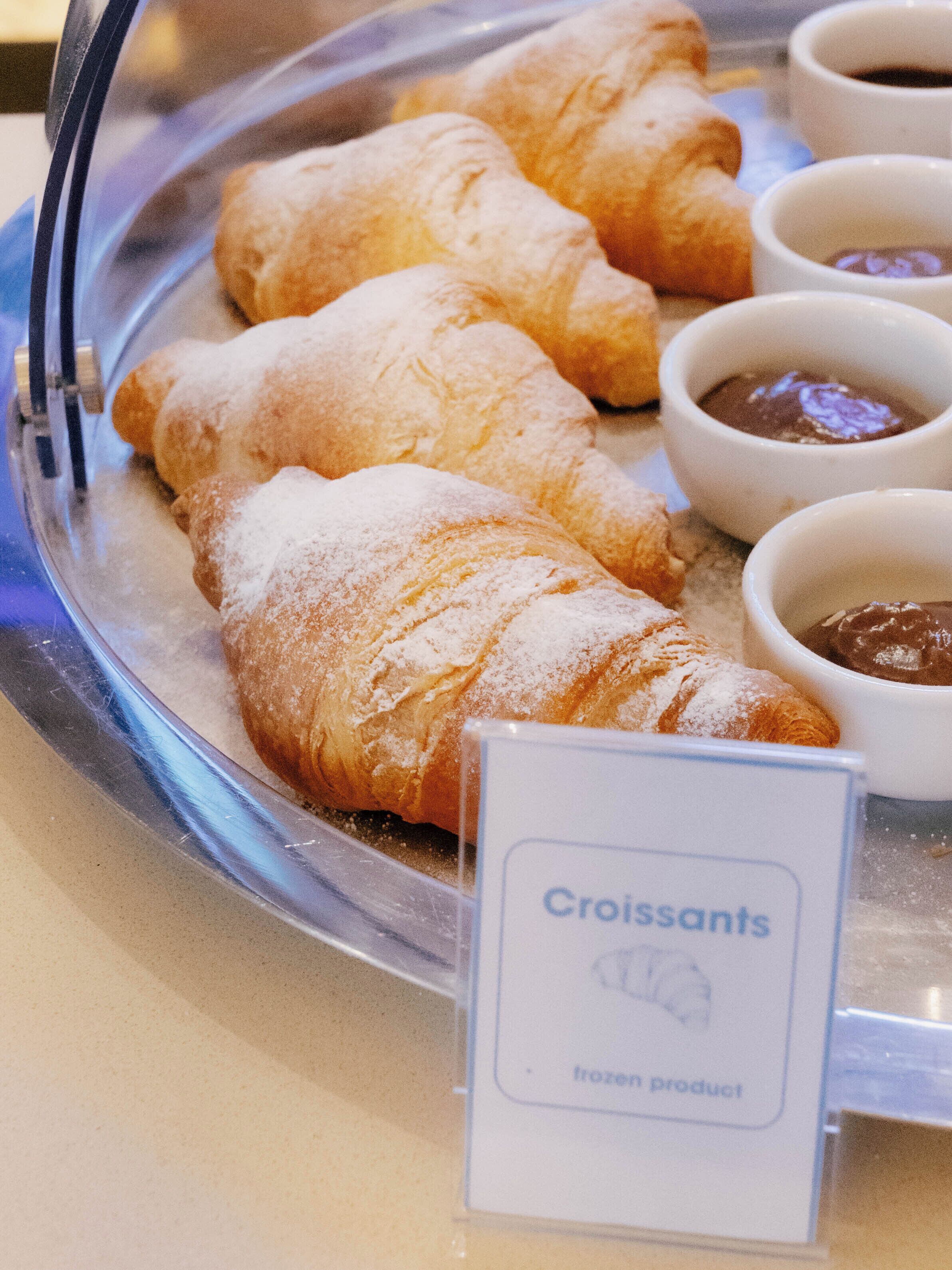 A tray of croissants and two small bowls of chocolate spread.