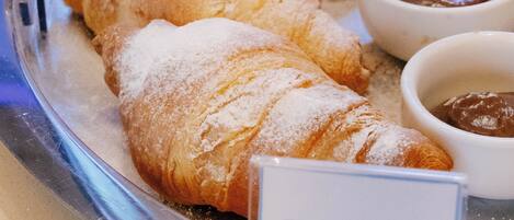 A tray of croissants and two small bowls of chocolate spread.
