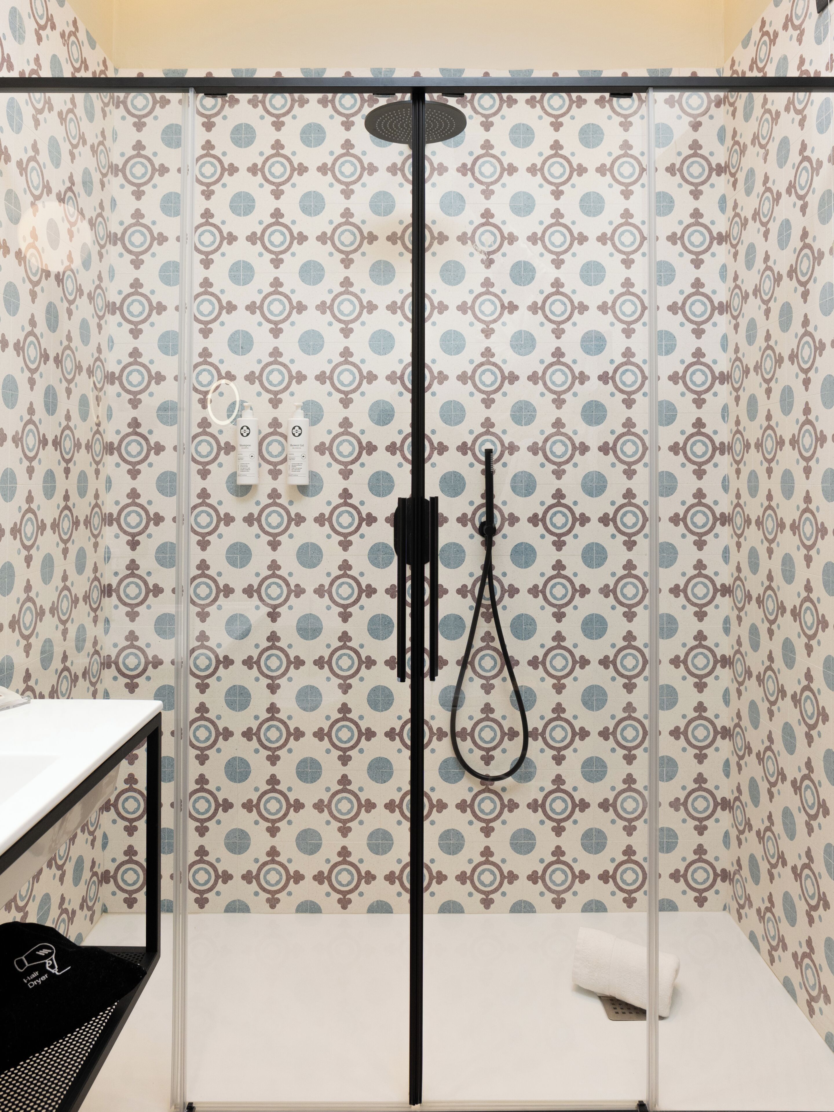 Une salle de bain avec une douche, un porte-serviettes et un lavabo.