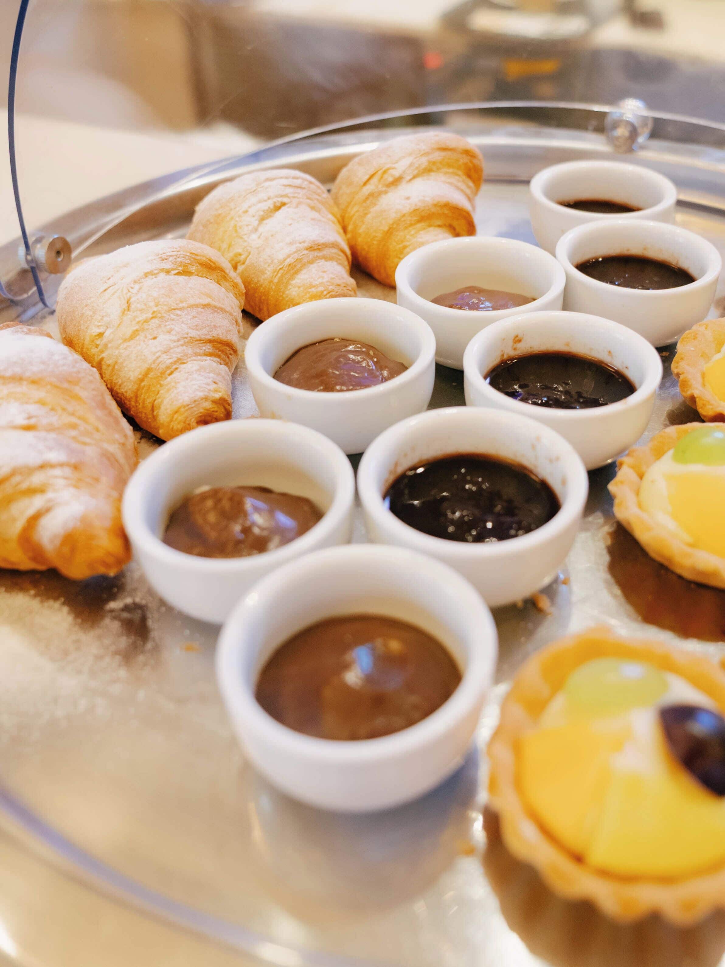 A tray with pastries and small bowls of spreads.