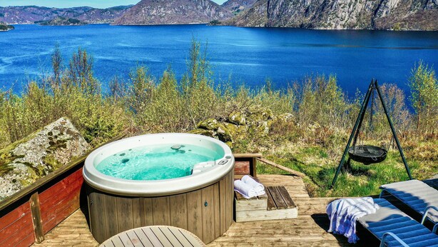 A hot tub on a wooden deck with a view of a lake and mountains. - Cozy home in Farsund with WiFi (Farsund)