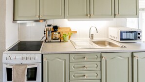 A kitchen with a stove, microwave, sink, and cabinets. - Cozy home in Farsund with WiFi (Farsund)