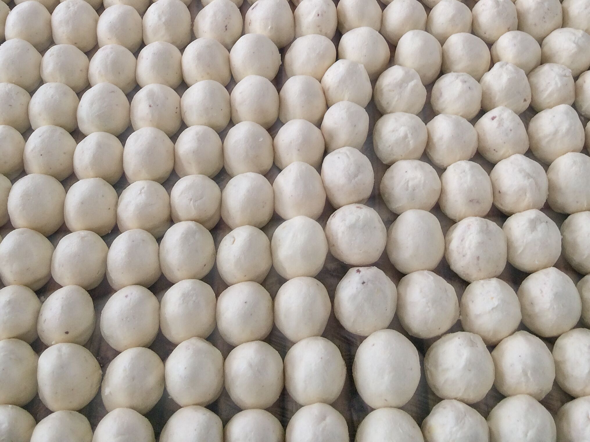 Un gros plan de sphères blanches, de forme uniforme, disposées selon un motif en grille.
