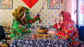 A room with patterned wallpaper, a red Chinese character decoration, and a framed picture on the wall.