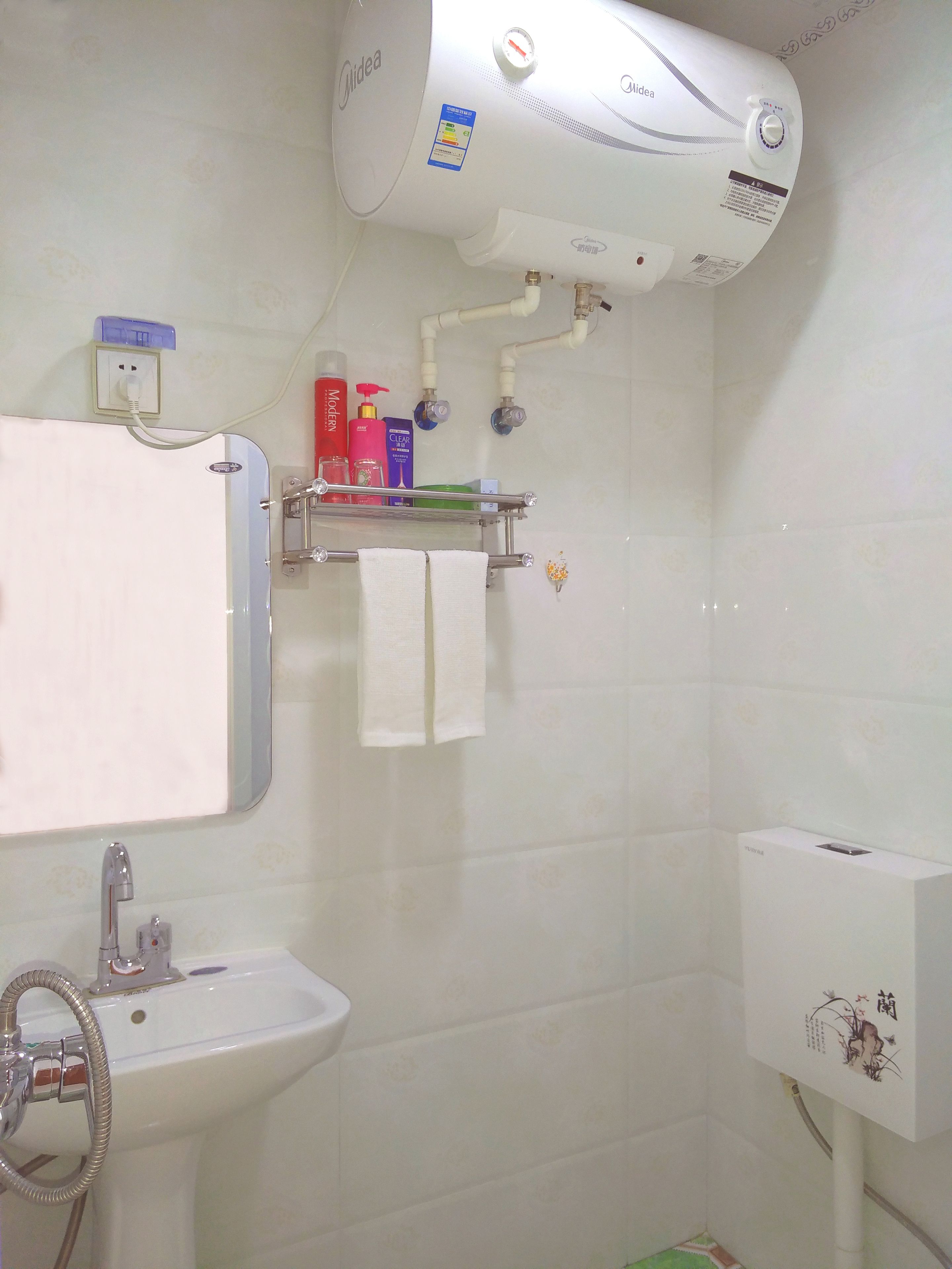 A bathroom with a white toilet, sink, and a wall-mounted air conditioner.